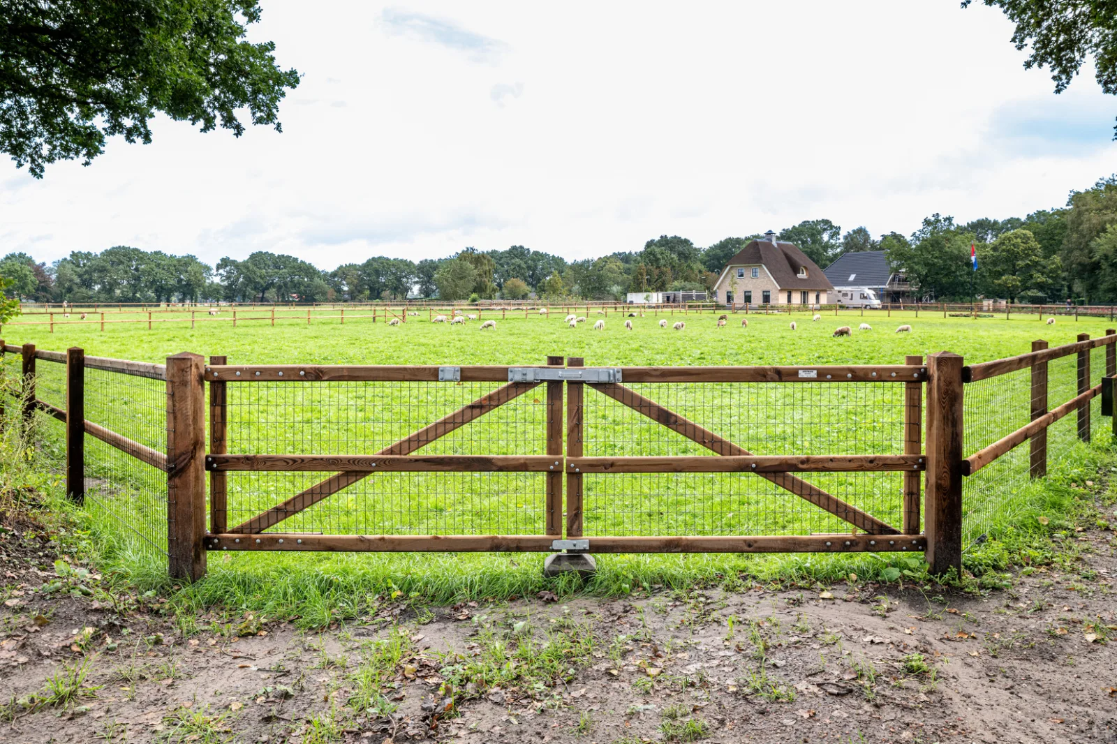 Houten poort in een Nobifix omheining rond een weiland